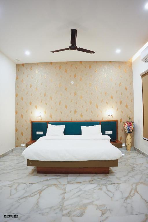 a bedroom with a large bed and a ceiling fan at The Krati Resort & Convention Centre in Bareilly