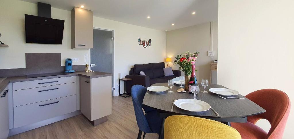 eine Küche und ein Wohnzimmer mit Tisch und Stühlen in der Unterkunft Appartement Au calme Quiberon in Quiberon