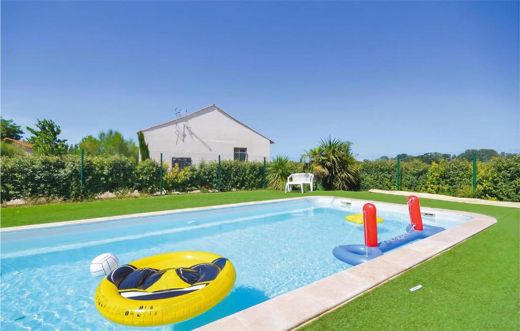 a swimming pool with two inflatables in a yard at Les Piboules in Arles