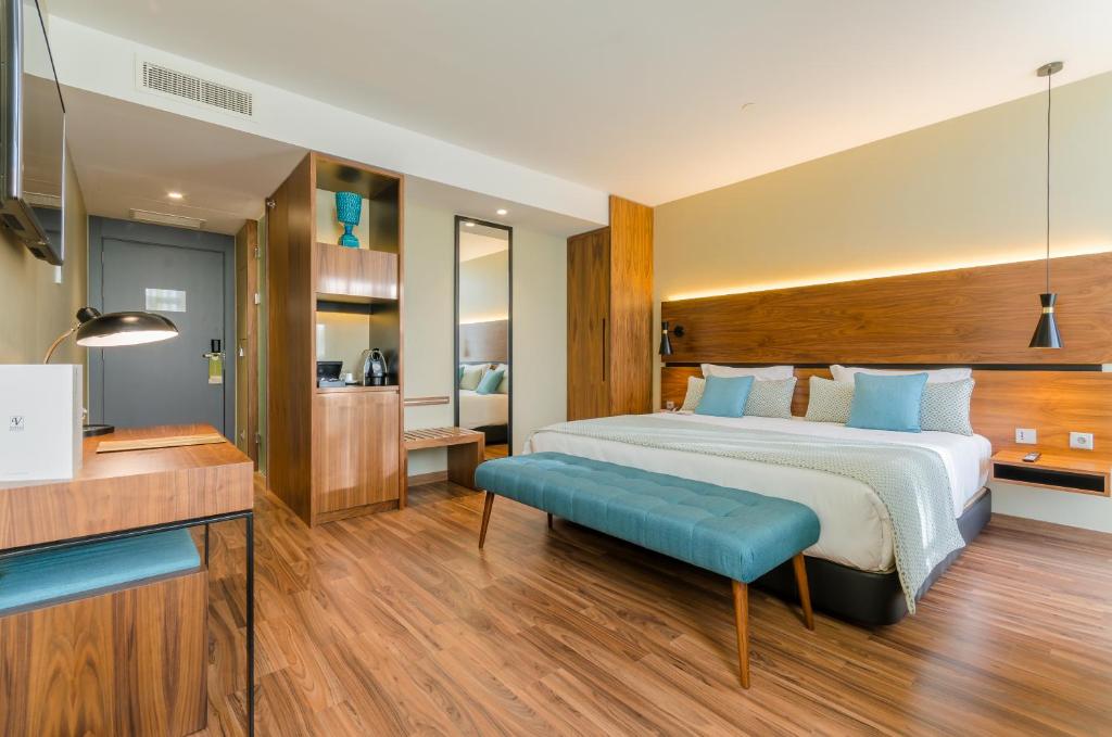 里斯本的住宿－利貝爾達迪文奇酒店，一间卧室设有一张大床和一张蓝色长凳