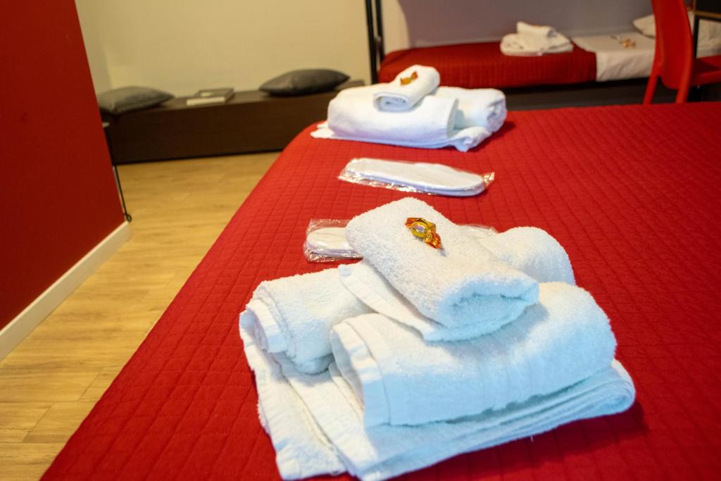 dwie sterty ręczników siedzące na czerwonym dywanie w obiekcie Emmanueli65 fronte clinica per 4 matrimoniale e castello w mieście Piacenza