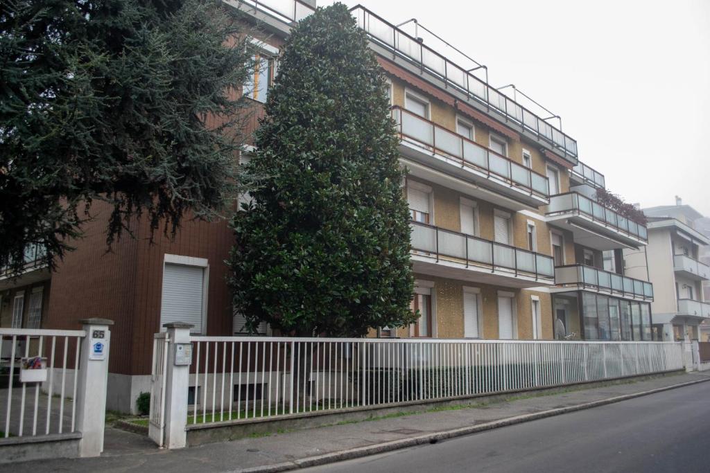 drzewo przed budynkiem z płotem w obiekcie Emmanueli65 fronte clinica per 4 matrimoniale e castello w mieście Piacenza