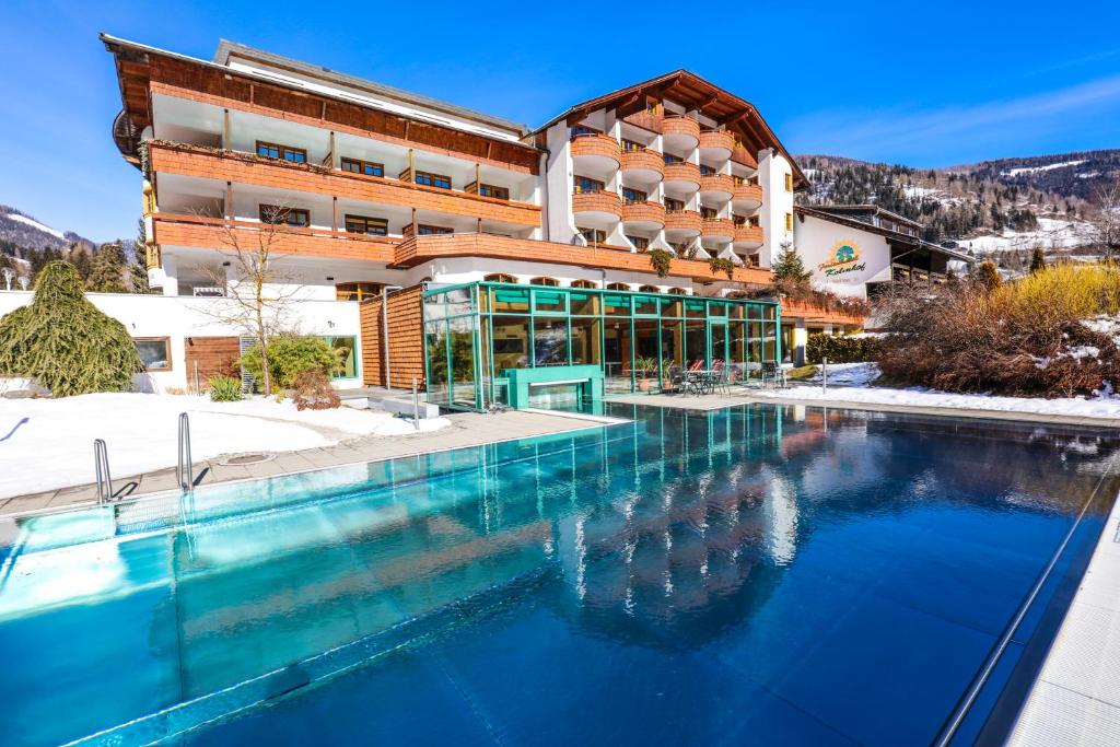een hotel met een zwembad voor een gebouw bij Kolmhof in Bad Kleinkirchheim
