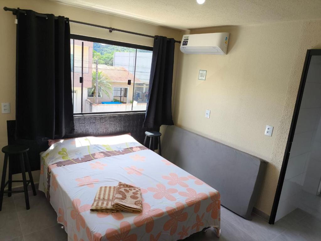 a small bedroom with a bed and a window at Casa de Praia Família Próximo ao ExpoCentro BC in Balneário Camboriú