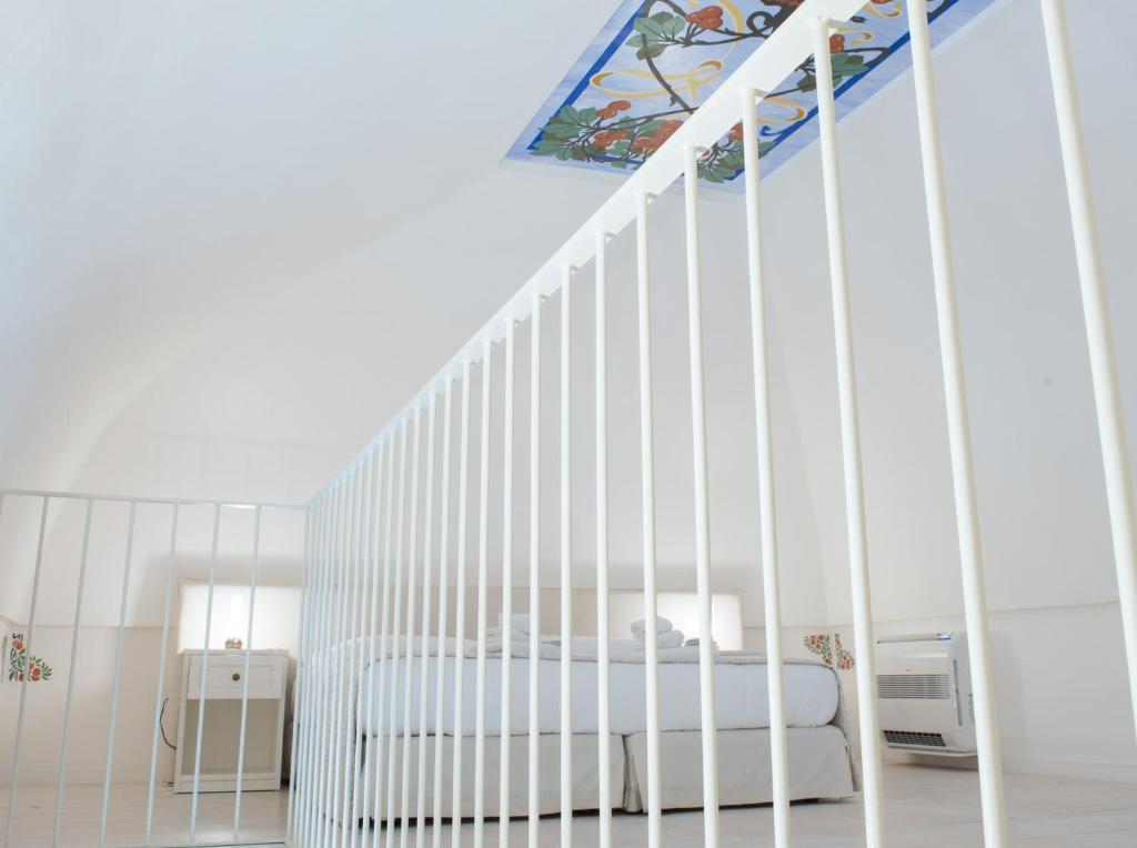 a white crib in a bedroom with a staircase at Dimora Dell'Osanna in Carovigno