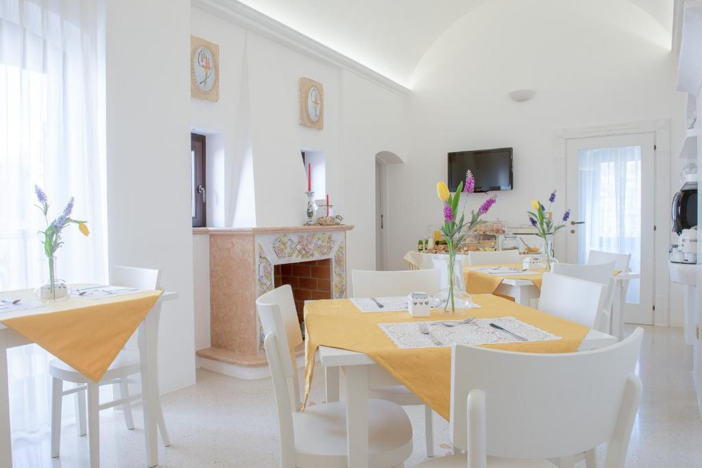 a dining room with a table and chairs and a fireplace at Dimora Dell'Osanna in Carovigno