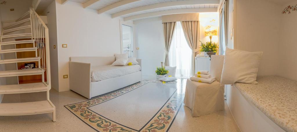 a white living room with a couch and a window at Dimora Dell'Osanna in Carovigno