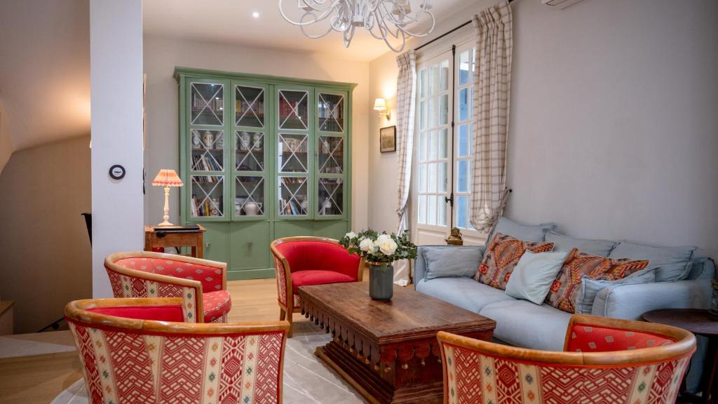 ein Wohnzimmer mit einer Couch und einem Tisch und Stühlen in der Unterkunft Villa Liska in Arcachon