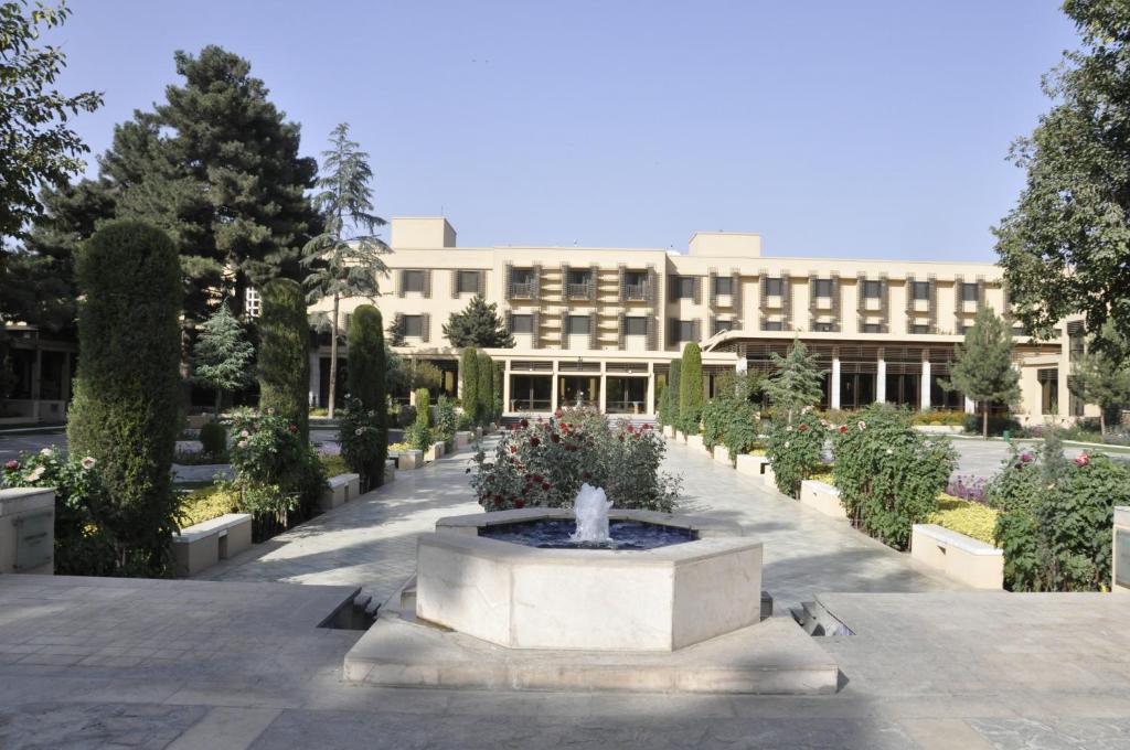 a building with a fountain in the middle of a courtyard at Kabul Serena Hotel in Kabul