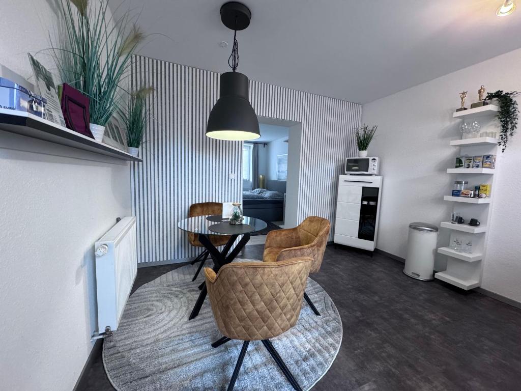 a living room with a table and chairs and a kitchen at Barrierefrei - 24Std-CHECK-IN kontaktlos - Kingsize Bed - W-LAN - Parkplatz W 3 in Bückeburg