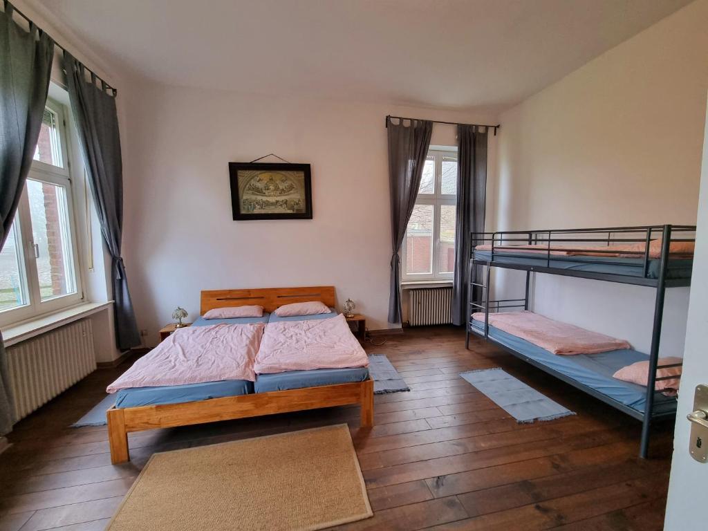 a bedroom with two bunk beds and two windows at Ferienwohnung Joseph im alten Pastorat in Kevelaer