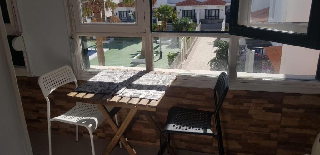 a table and two chairs in front of a window at Disfruta el Puertito de Güímar in Puertito de Güímar