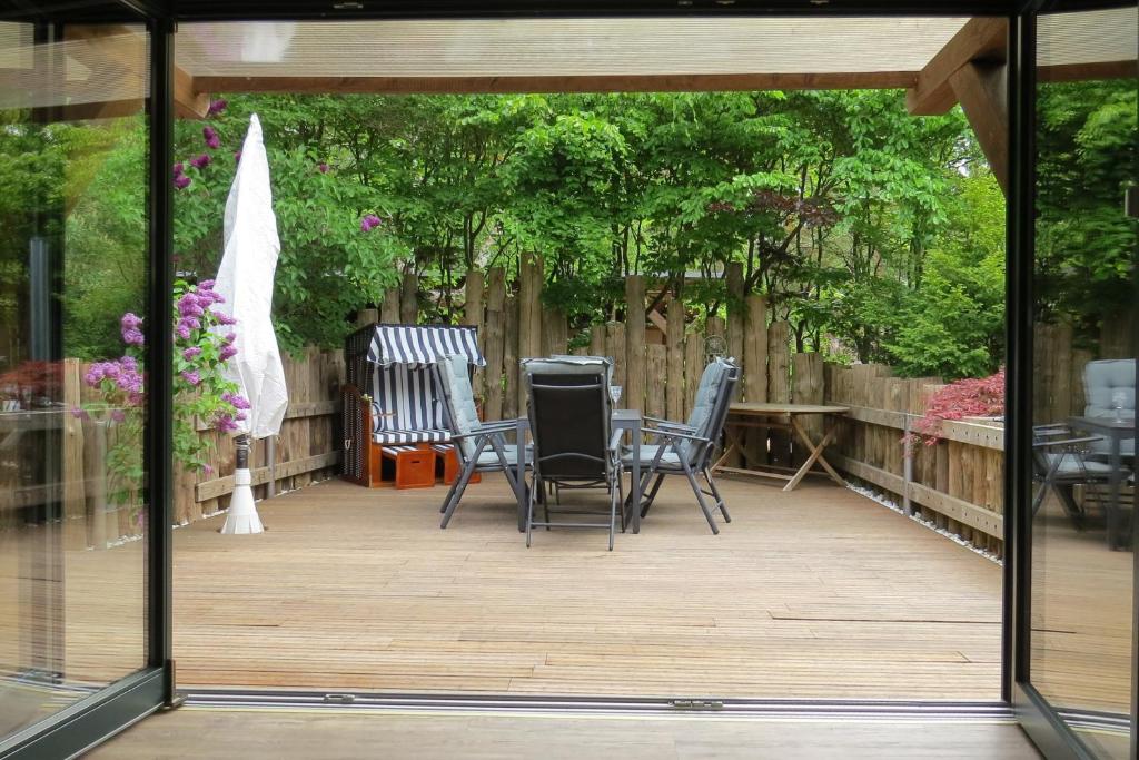 a screened in patio with chairs and trees at Strandhaus Möve in Wustrow