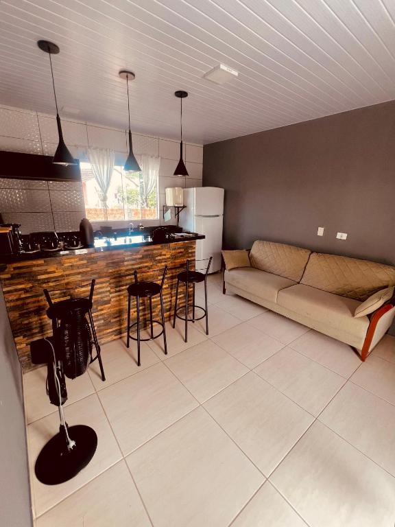 a kitchen and living room with a couch and a table at Casa na Praia de Canoas in Pontal do Paraná