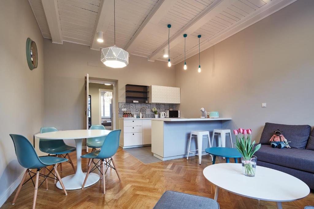 a living room with a couch and a table and chairs at PlayRoom II Apartment in Krakow