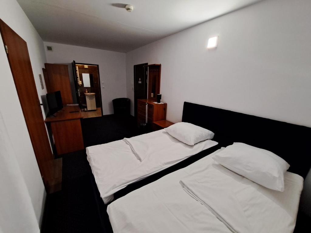 sypialnia z 2 łóżkami z białą pościelą w obiekcie Hotel Agat & SPA w Bydgoszczy