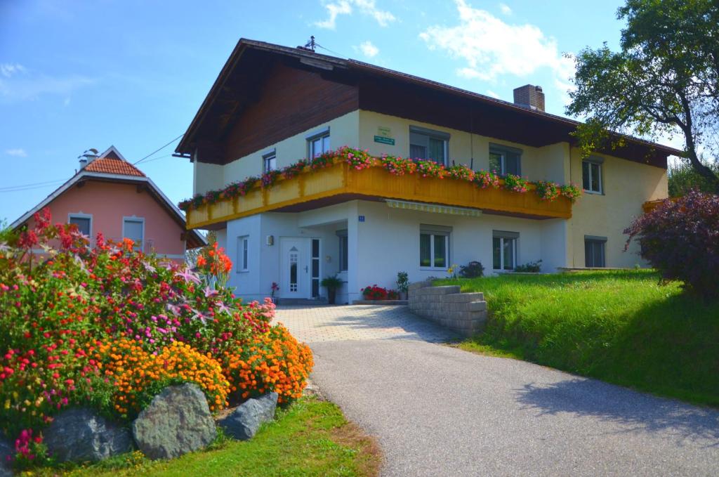 una casa grande con flores delante en Ferienwohnung Martinschitz, en Sankt Kanzian