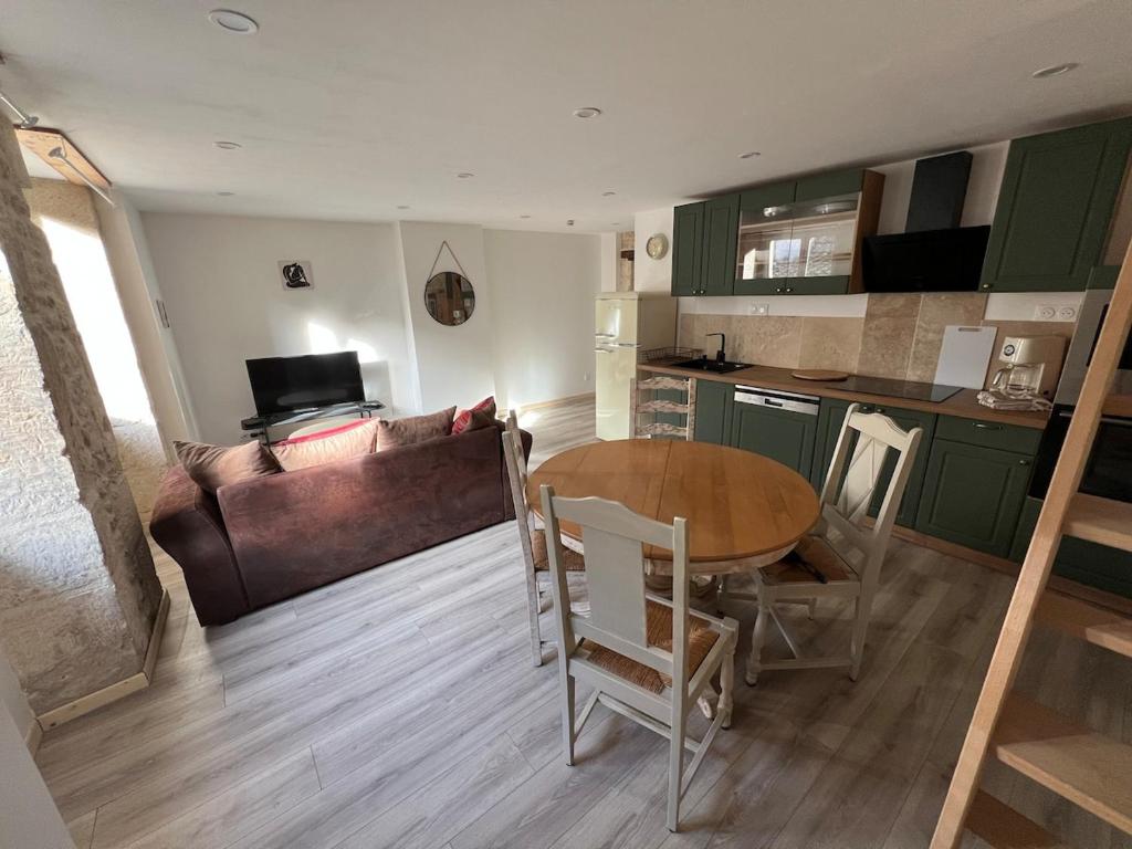 une cuisine et un salon avec une table et un canapé dans l'établissement Appart Montignac, à Montignac