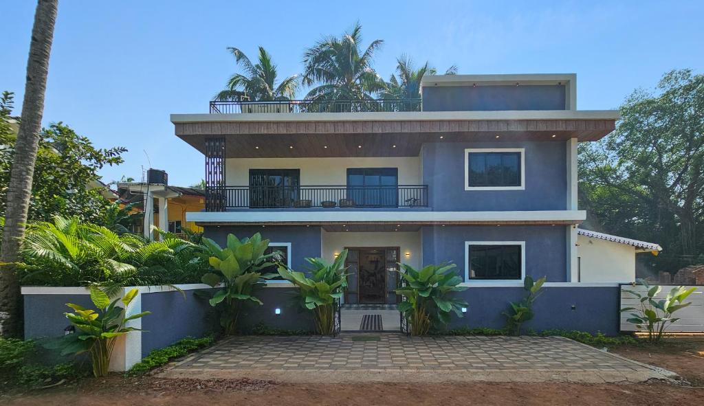 una casa azul con balcón en la parte superior en House Of Josma By There4You Tourism, en Candolim