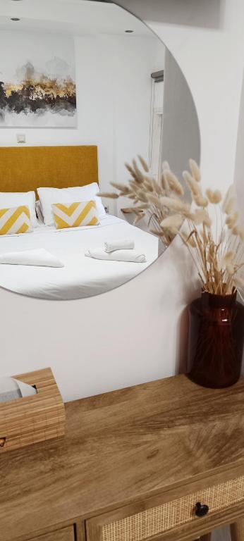 a bedroom with a large bed and a vase with a plant at Apeiron Acropolis Suites in Athens