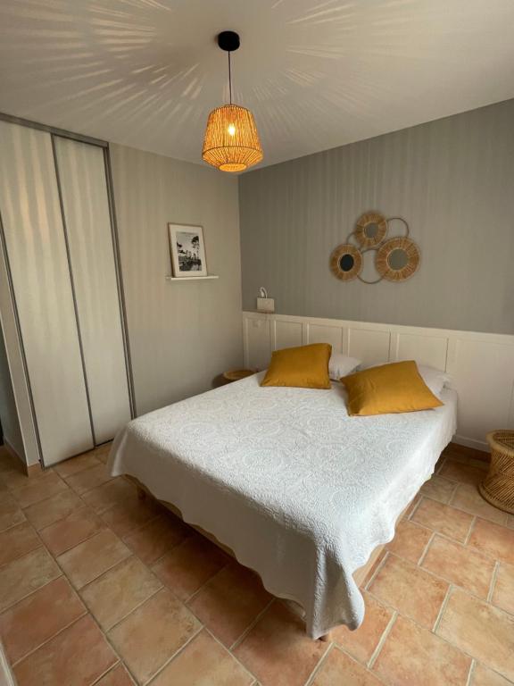 ein Schlafzimmer mit einem weißen Bett und einer Decke in der Unterkunft Chez Francis & Valérie in Villegailhenc