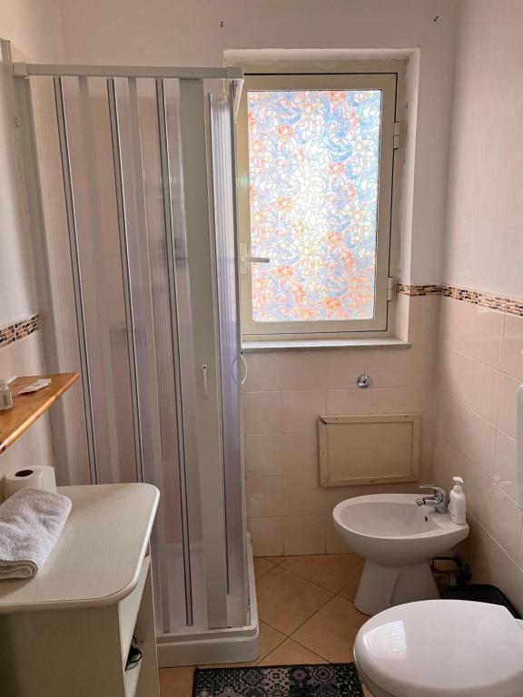 a bathroom with a shower and a toilet and a window at House del Corso Calatafimi in Palermo