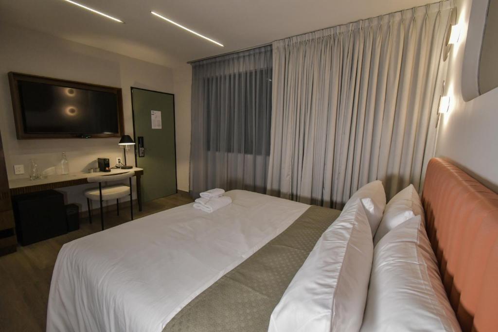 Postel nebo postele na pokoji v ubytování Expo Satelite 2750 Hotel & Suites
