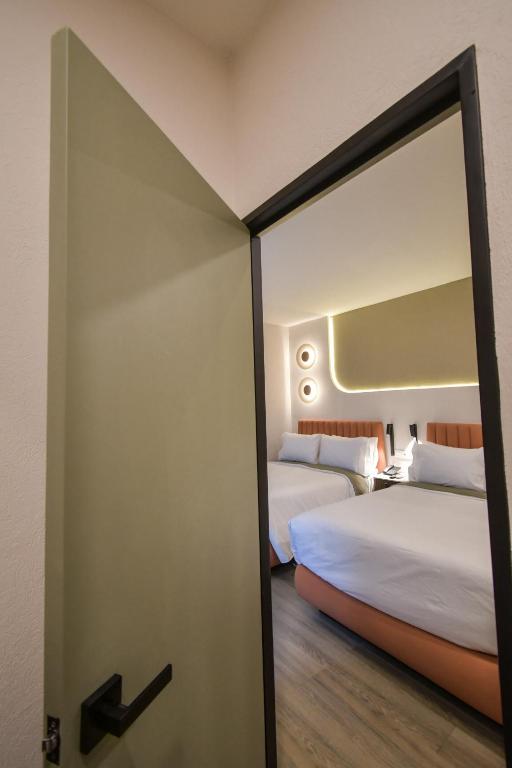 Postel nebo postele na pokoji v ubytování Expo Satelite 2750 Hotel & Suites