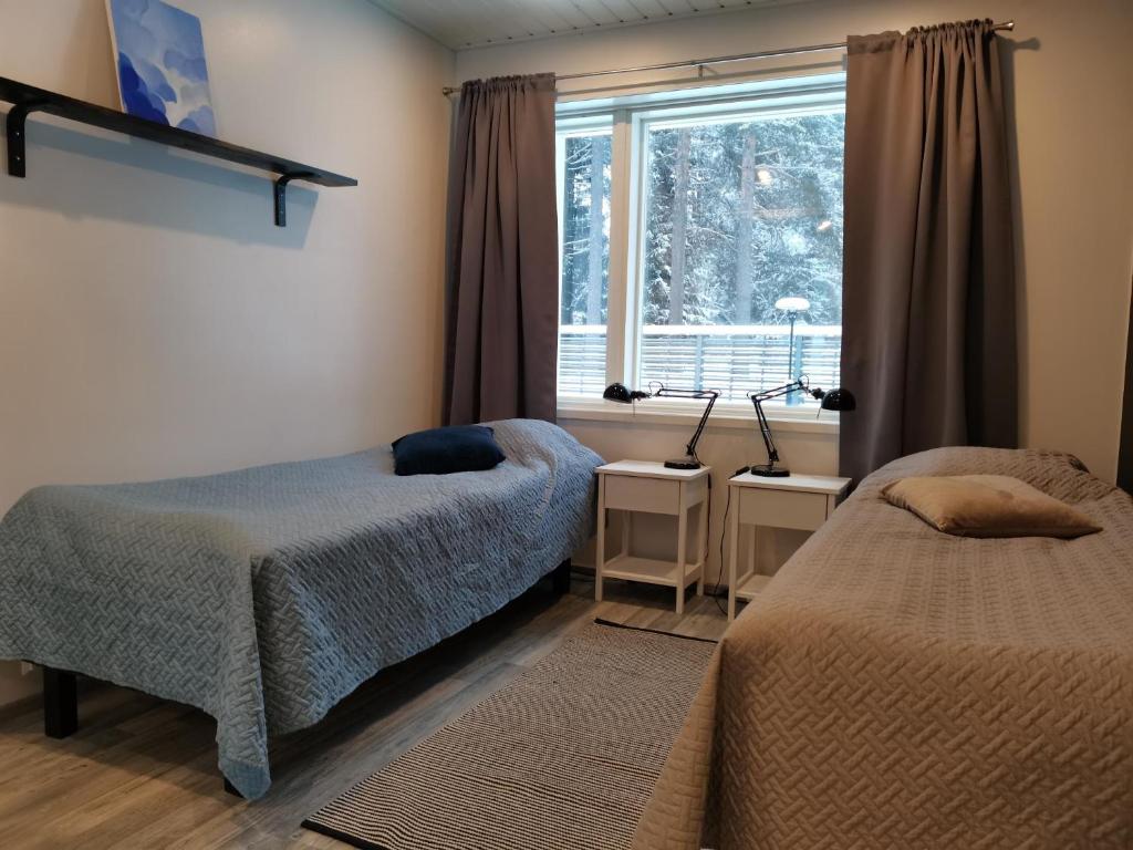 a bedroom with two beds and a window at Hostelli Jokiranta in Lieksa