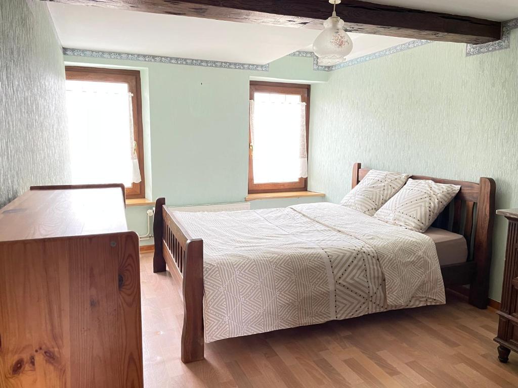 une chambre avec un lit et deux fenêtres dans l'établissement Chambre double à louer, à Kirrberg