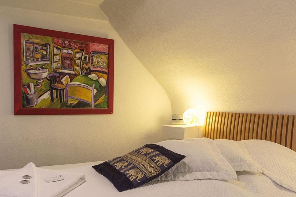 a bedroom with a bed and a painting on the wall at Frauenhotel Hanseatin - Women Only in Hamburg