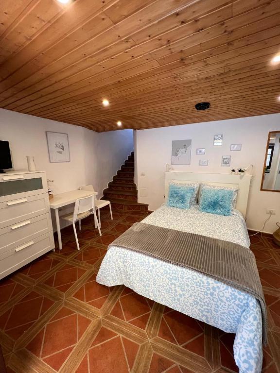 a bedroom with a bed and a desk and a staircase at El Pequeño Refugio - C in Chío