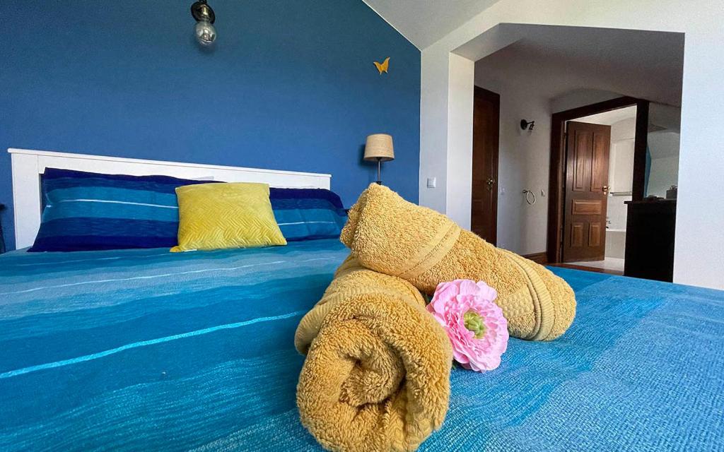 a bed with a stuffed animal on top of it at Solar Alegria Lodge in Oliveira de Frades