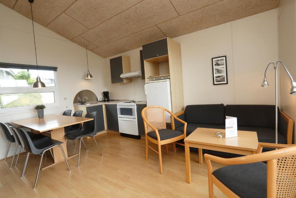 cocina y sala de estar con mesas y sillas en First Camp Bøjden Strand, en Faaborg