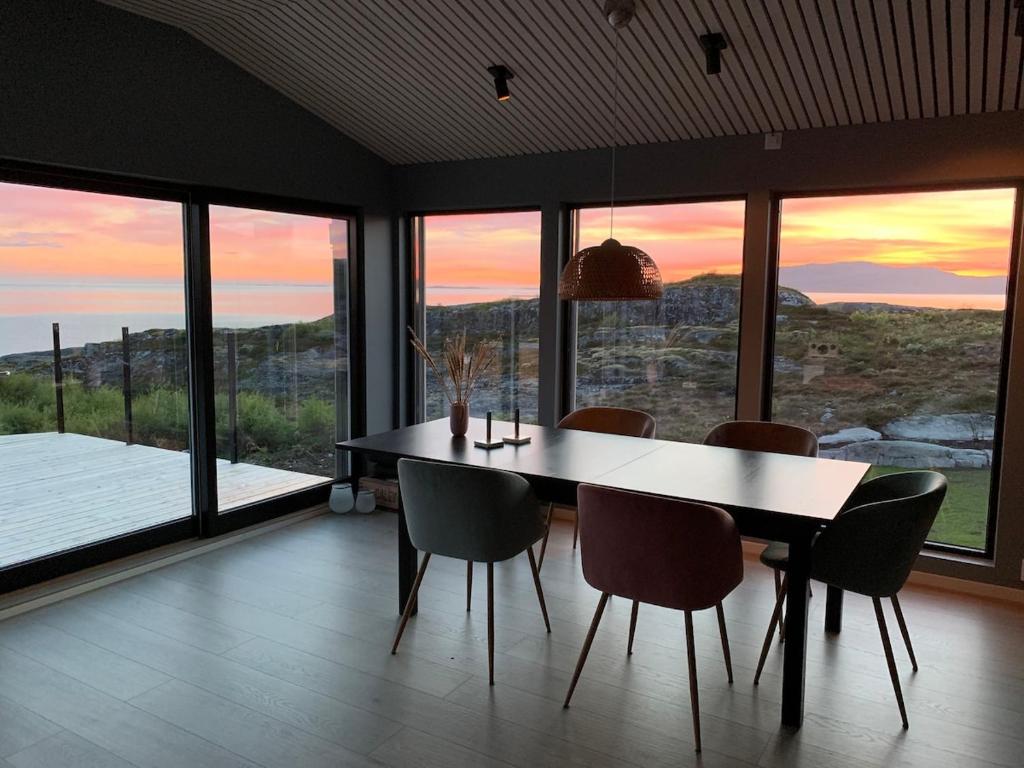 a dining room with a table and chairs with a view at Great cottage with unique views and high standard in Tørhogg