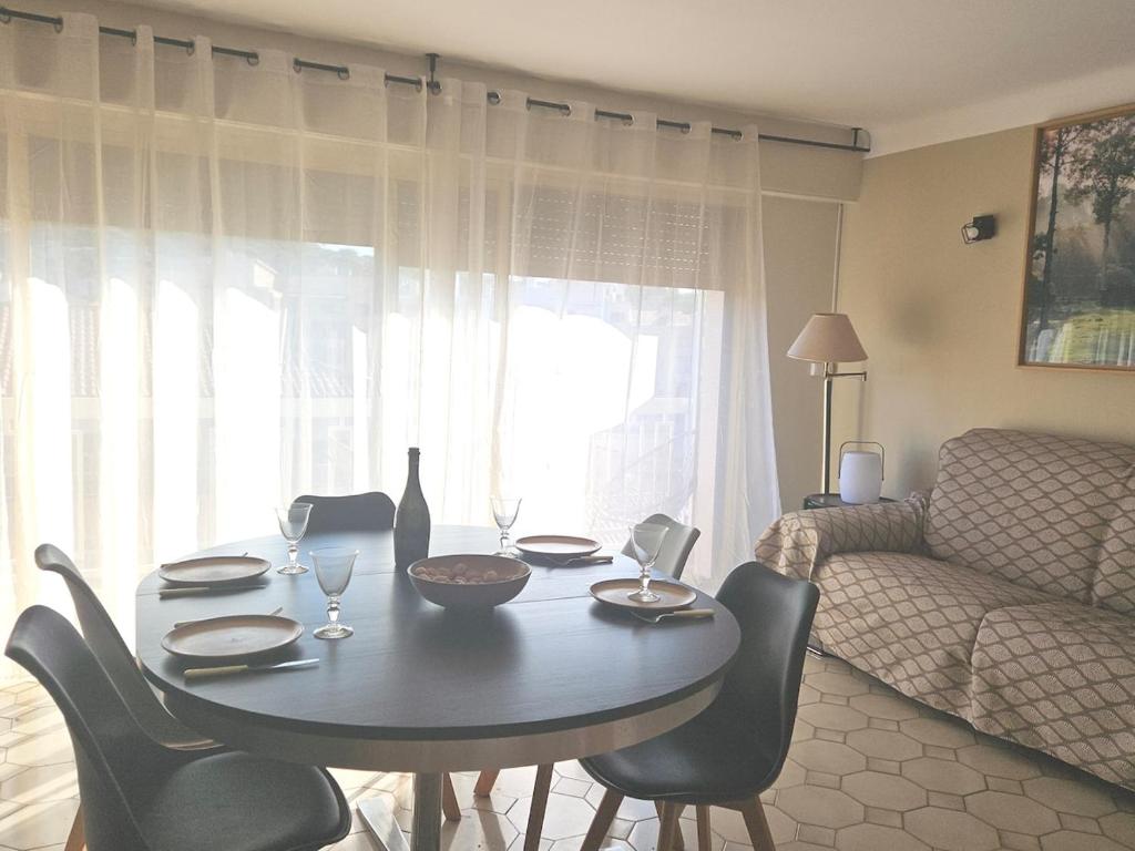 une table à manger et des chaises dans un salon dans l'établissement Appartement entre plage et ville, à Sainte-Maxime