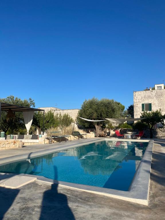 a shadow of a person standing next to a swimming pool at Casettina Matilda in Ostuni