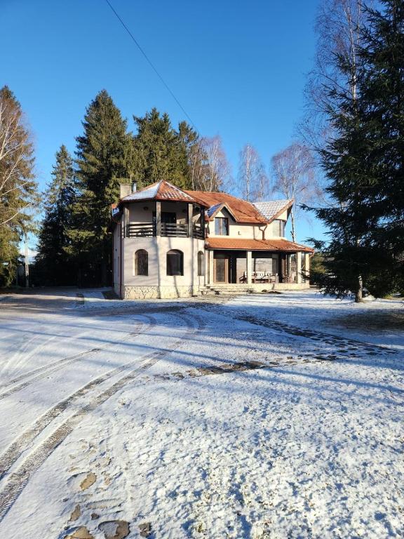 una casa vieja en la nieve con una entrada en Cabana Dealul Negru, en Dealu Negru