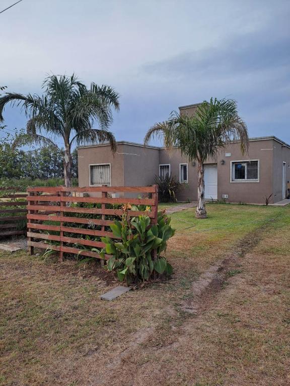 a house with a fence and two palm trees at posada acevedo in Acevedo