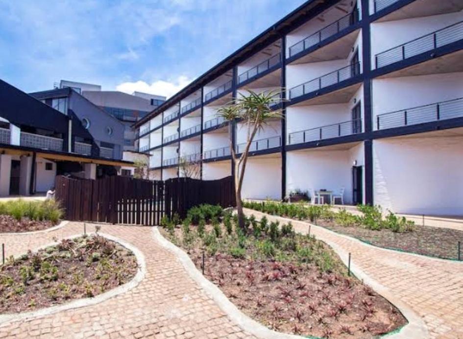 a building with a palm tree in a courtyard at The Hills by maboneng in Johannesburg