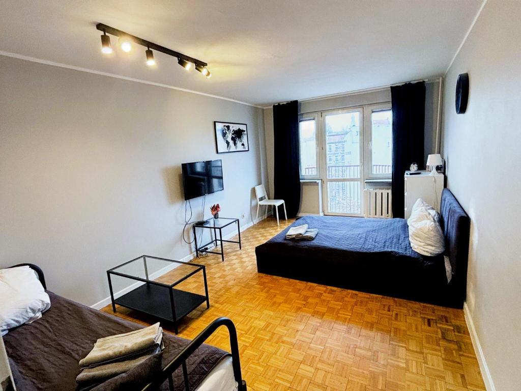 ein Schlafzimmer mit einem Bett und einer Couch in der Unterkunft Stanisława Dubois 29, Wrocław in Breslau