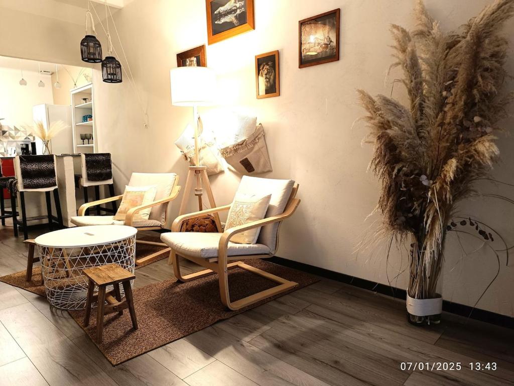 Cette chambre comprend un bouquet de chaises et une table. dans l'établissement Bormes Village appartement 2 chambres, à Bormes-les-Mimosas