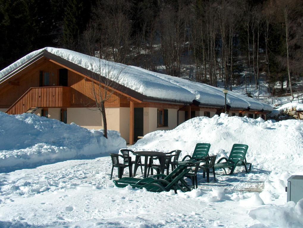 a group of chairs and a table in the snow at Chalet Presanella in Temù