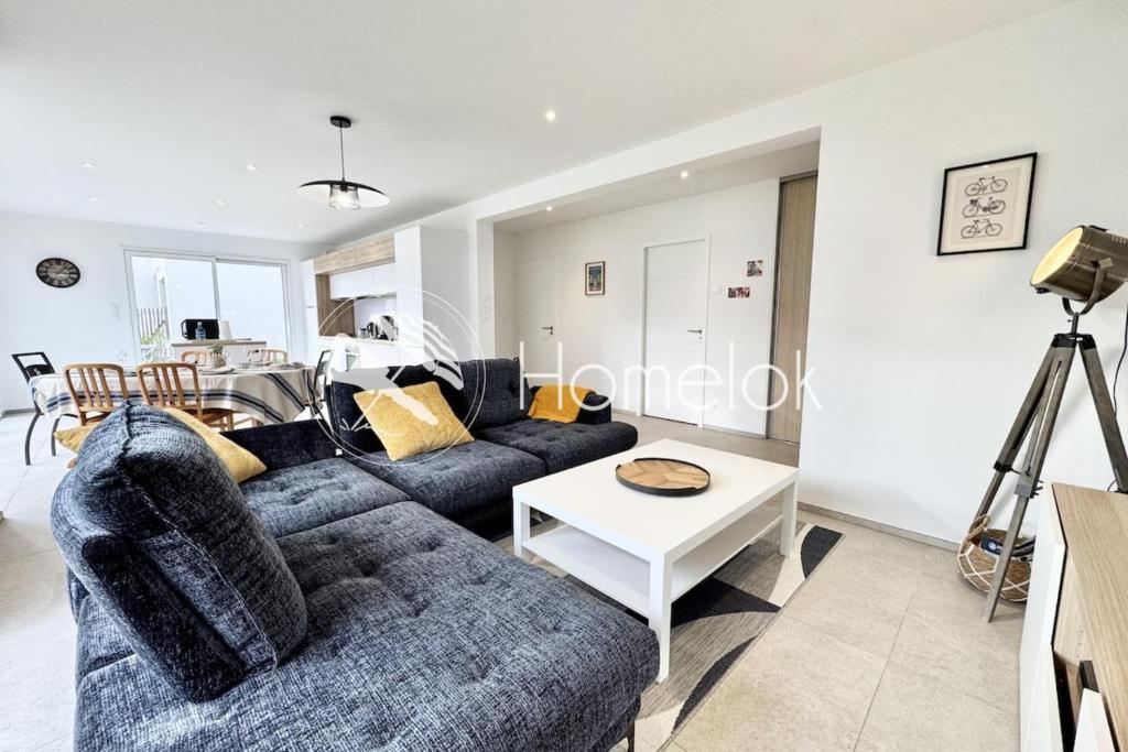 un salon avec un canapé et une table dans l'établissement Maison neuve contemporaine - 10min des plages, à Saint-Pierre-Quiberon