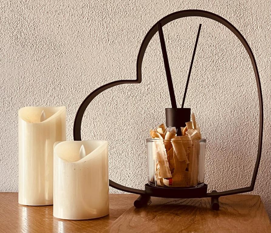 un candelabro a forma di cuore su un tavolo con due candele di Appartamento Cuore delle Dolomiti a Cencenighe