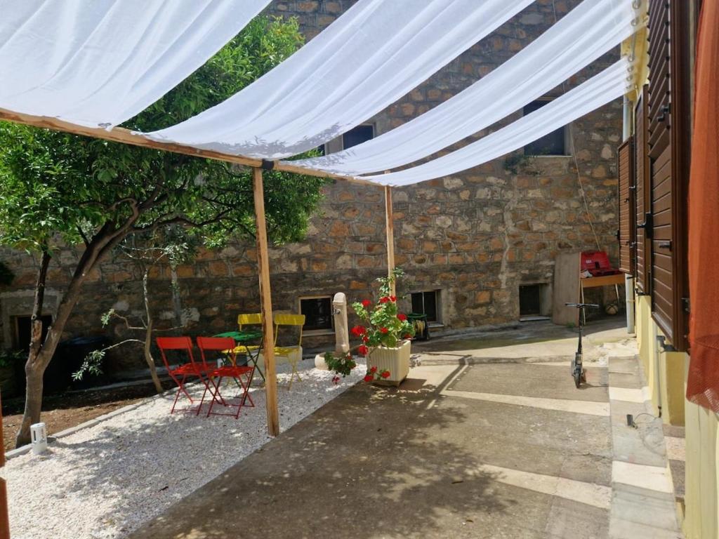 toldo sobre un patio con sillas y mesa en Accogliente a 2minuti dal mare, en Santa Maria Navarrese