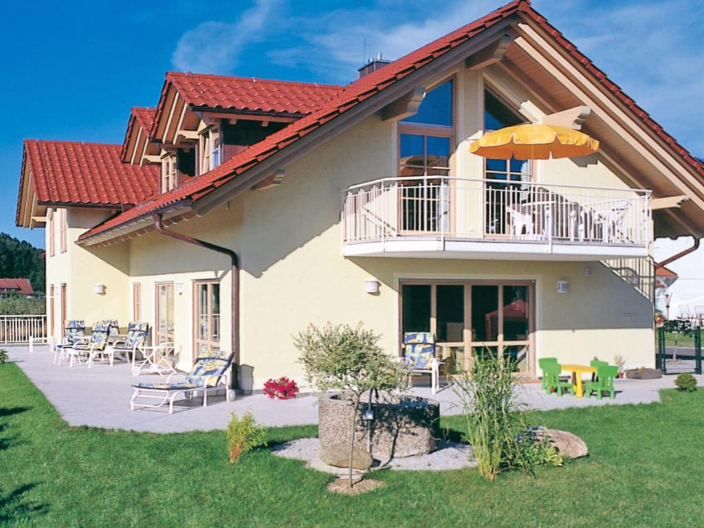 ein Haus mit einem Balkon und einem Sonnenschirm in der Unterkunft Ferienwohnung Hütt in Wasserburg