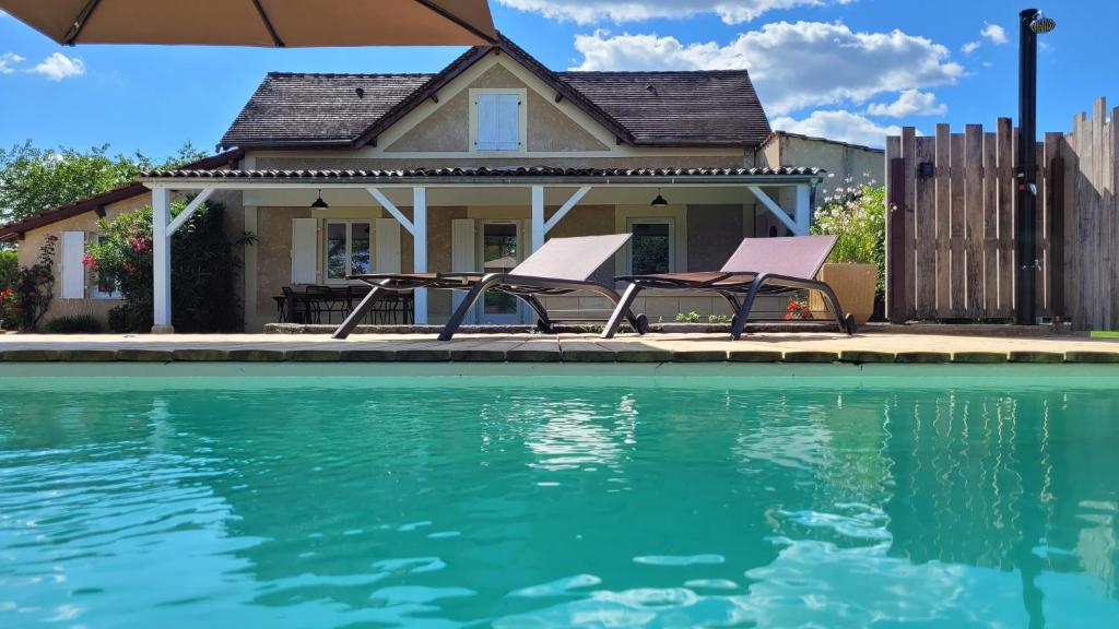 a house with two chairs and a swimming pool at Le Quai in Saint-Vincent-de-Cosse
