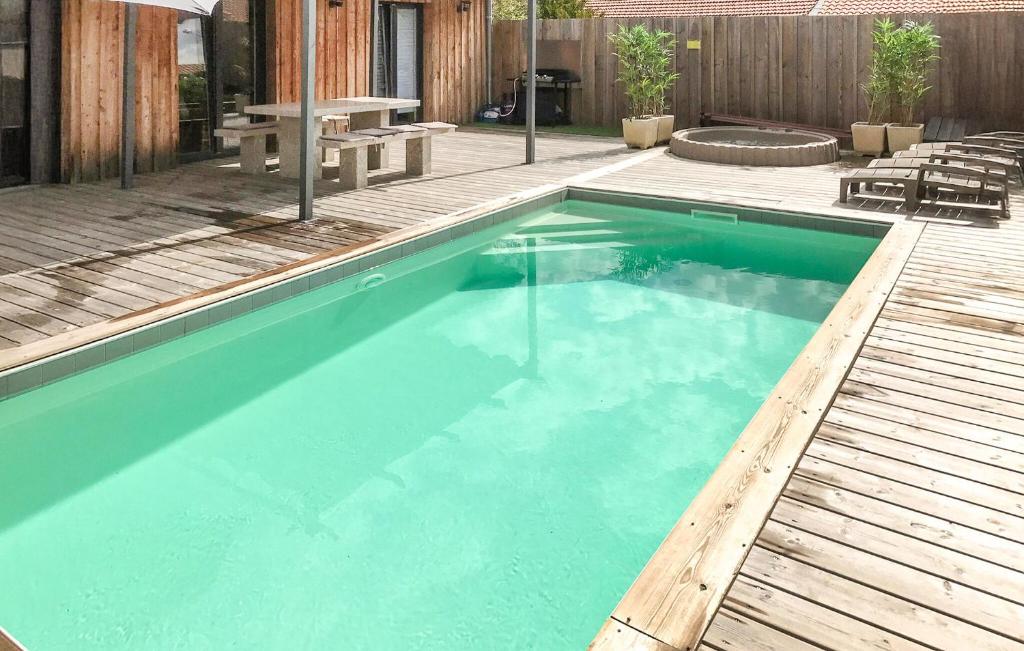 a large swimming pool with a wooden deck at Beautiful Home In Ares in Arès