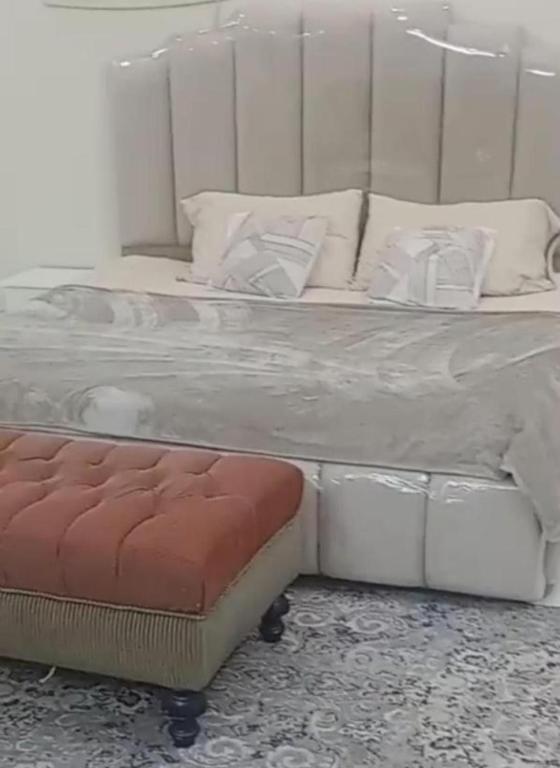 a large white bed with a bench next to it at البيت بيتك للضيافة الخاصة in Mecca